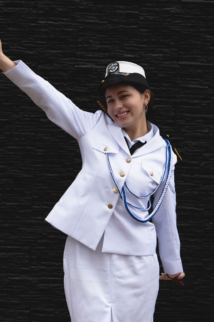 Crafting Captivating Headlines: Your awesome post title goes here Portrait of a smiling woman in a white military uniform against a black background.